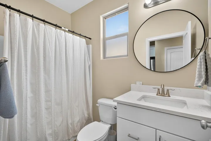 Contemporary bathroom vanity with a white rectangular sink, light-colored countertop, and brushed nickel faucet
