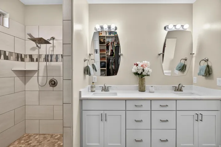 Dual vanity with white shaker-style cabinetry, white quartz countertops, and brushed nickel fixtures