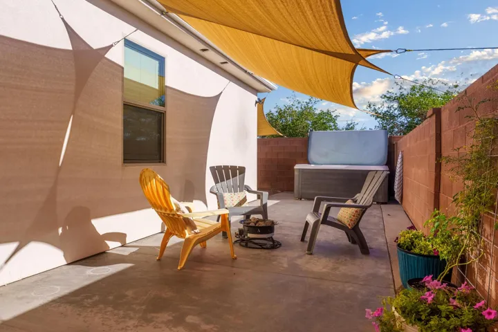 Private patio space featuring a concrete slab and shade sails