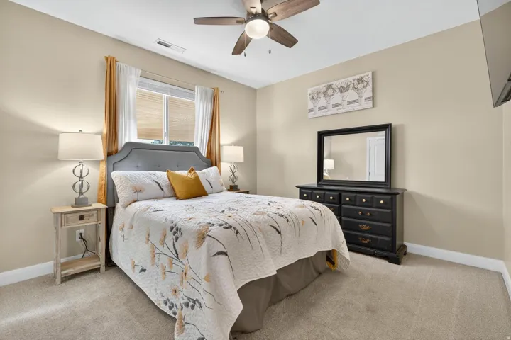 Well-lit room featuring a window with blinds, a ceiling fan, and neutral-toned walls