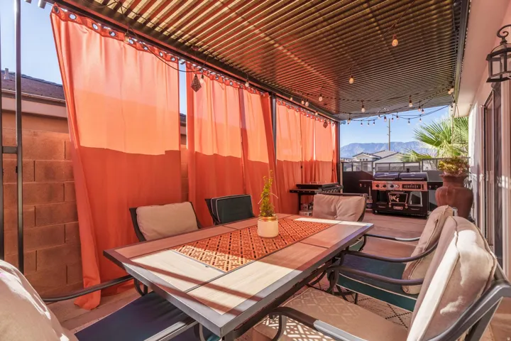 Covered patio featuring a corrugated metal roof, privacy curtains, and string lighting