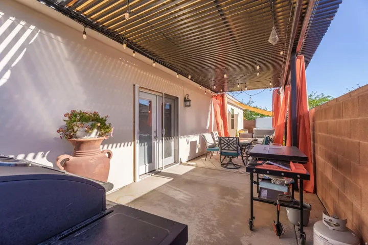Expansive covered patio featuring a corrugated metal roof, string lights, and concrete flooring