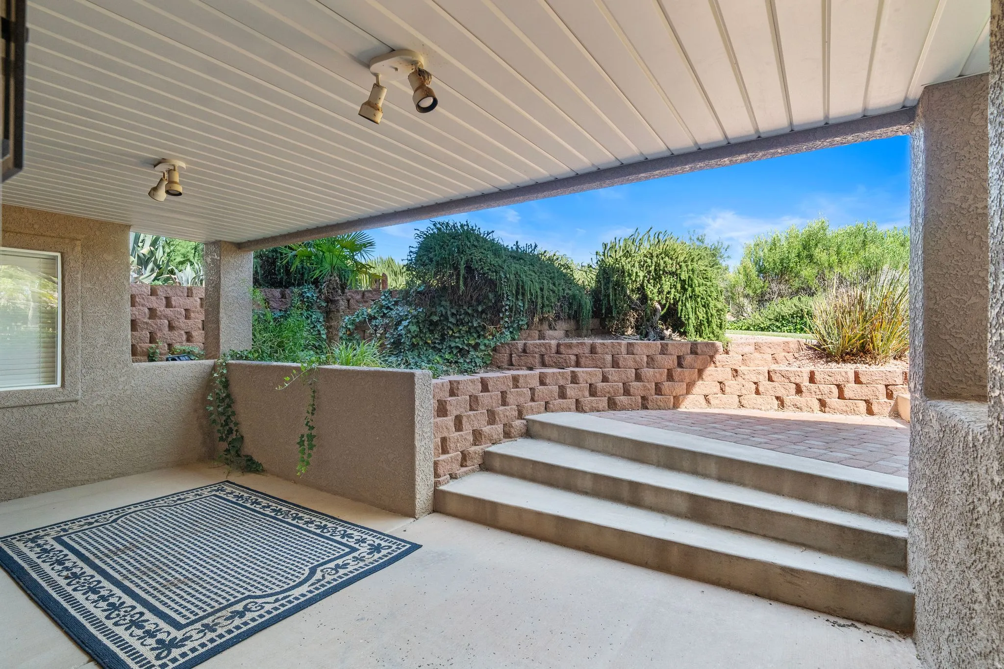 Covered patio with textured stucco walls and a paneled ceiling