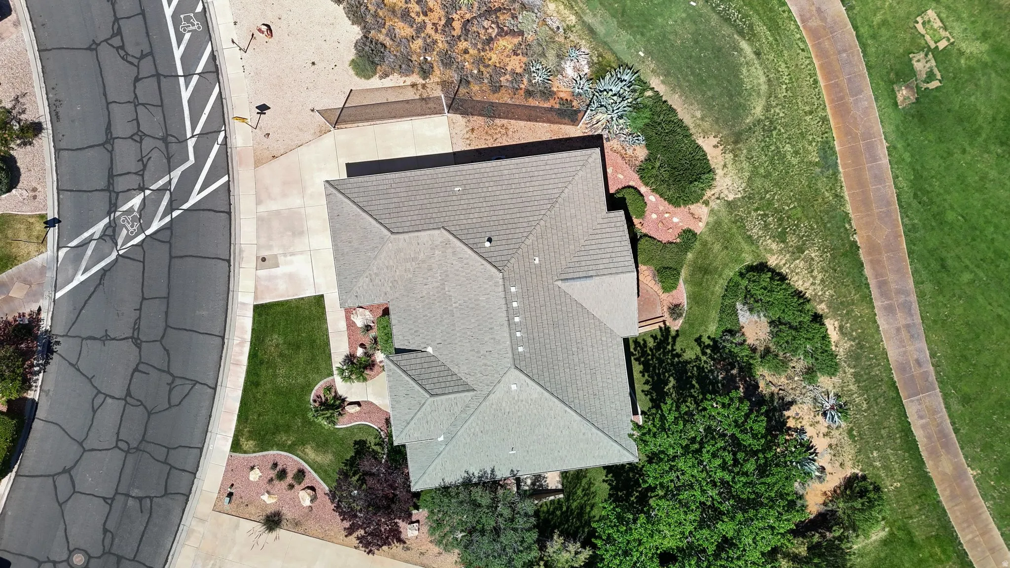 Aerial perspective highlighting the property with a shingle roof and surrounding landscaping