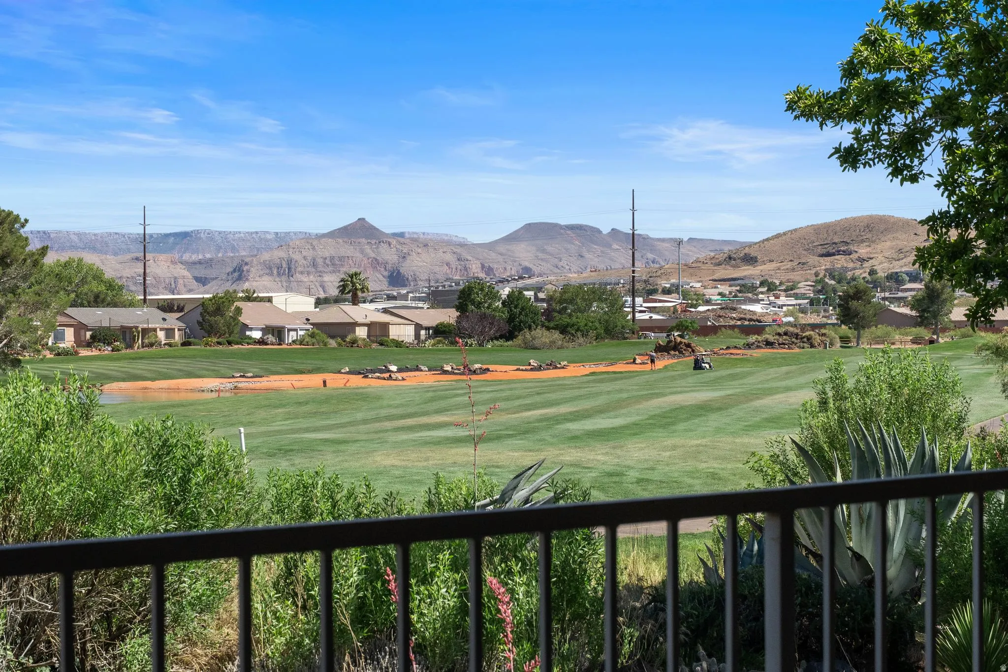 Expansive golf course frontage with manicured fairways and distant mountain ranges