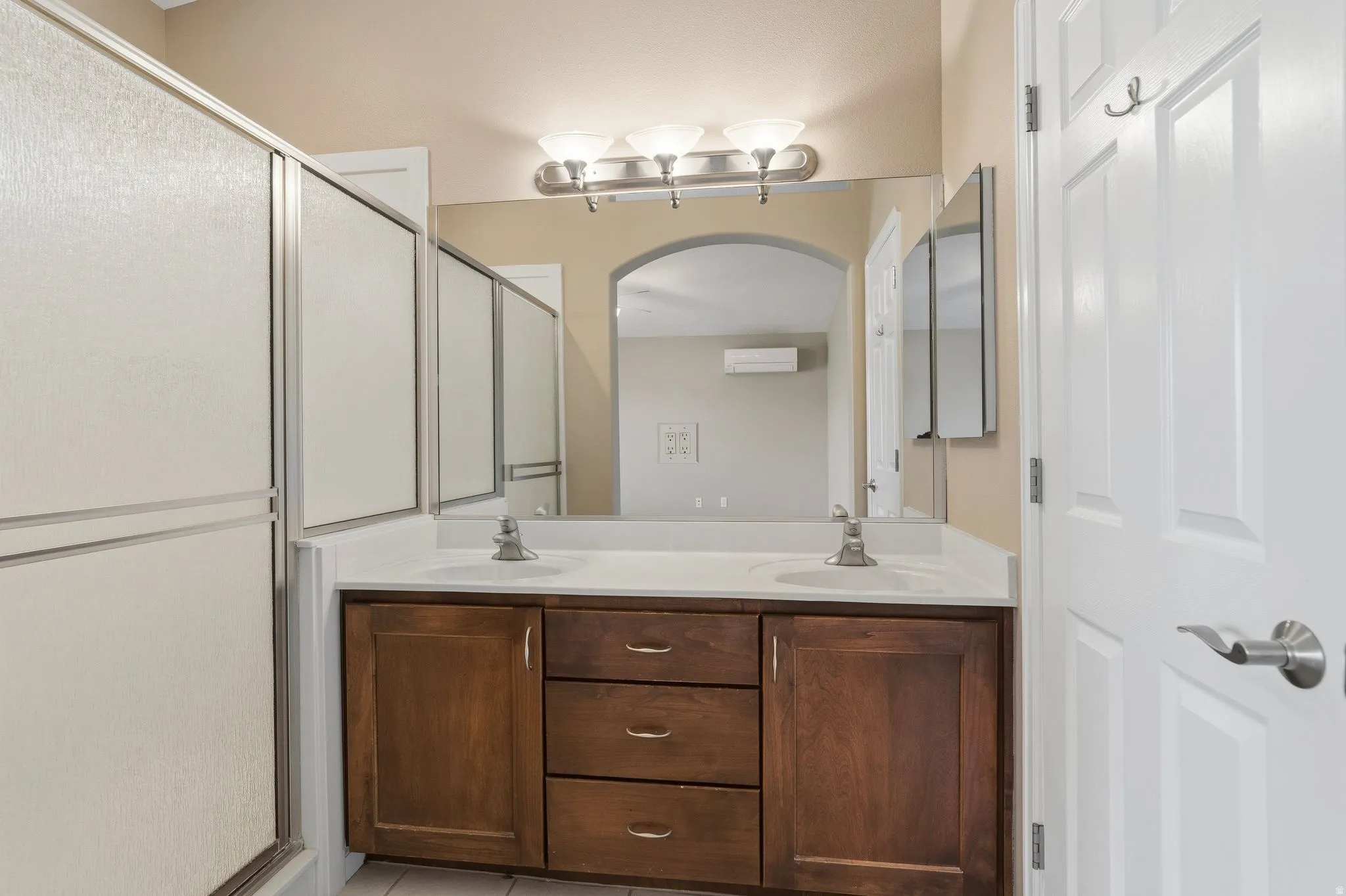Dual vanity with wood-finish cabinetry and white countertop