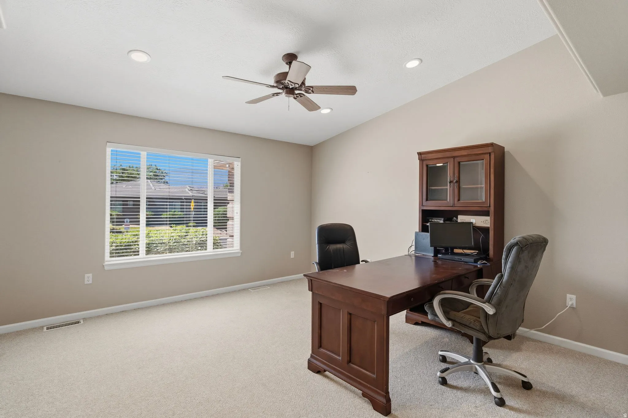 Spacious room featuring vaulted ceilings, recessed lighting, and a ceiling fan