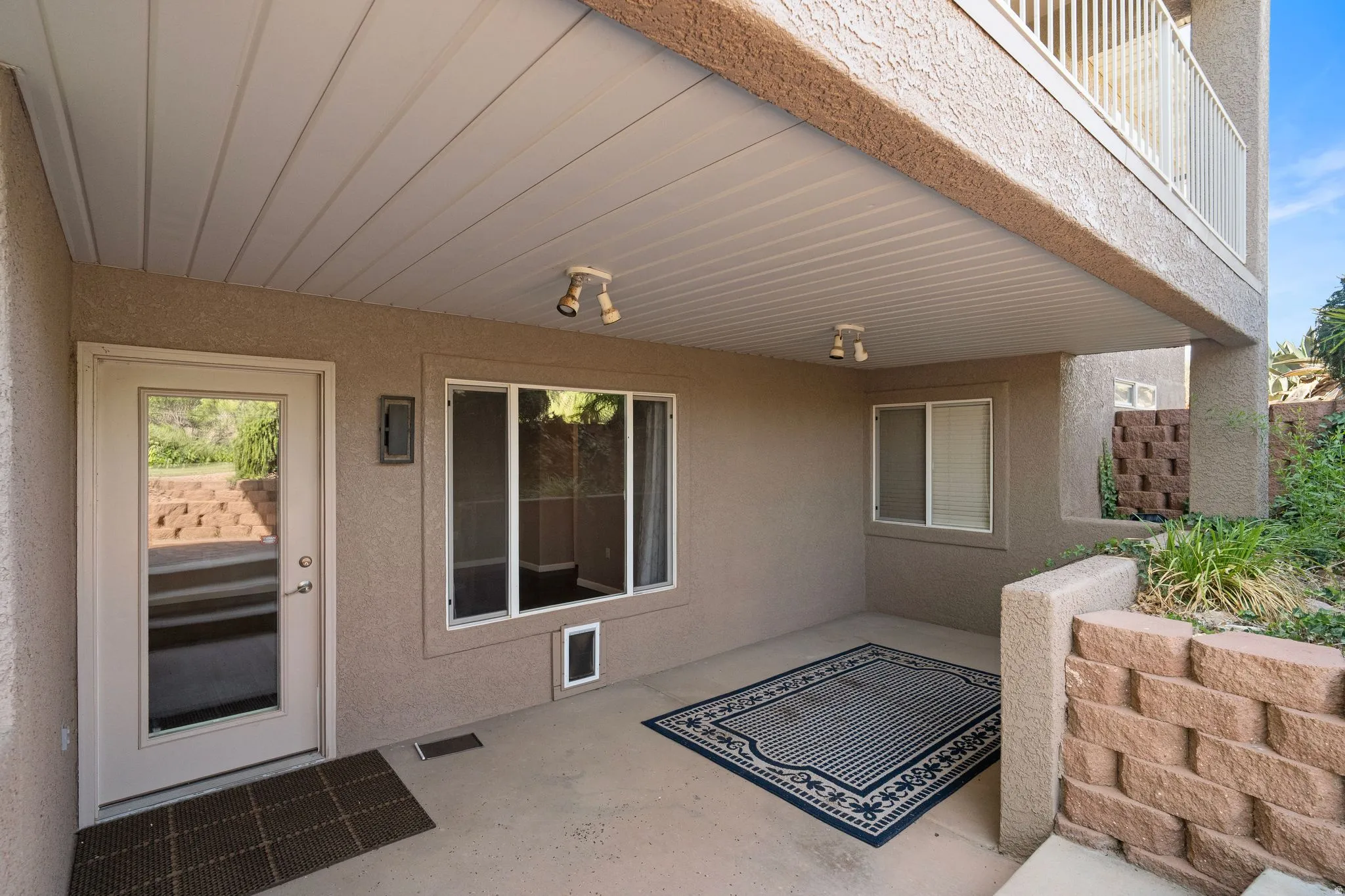 Covered patio featuring a solid ceiling, recessed lighting, concrete flooring, and an exterior door with glass insert