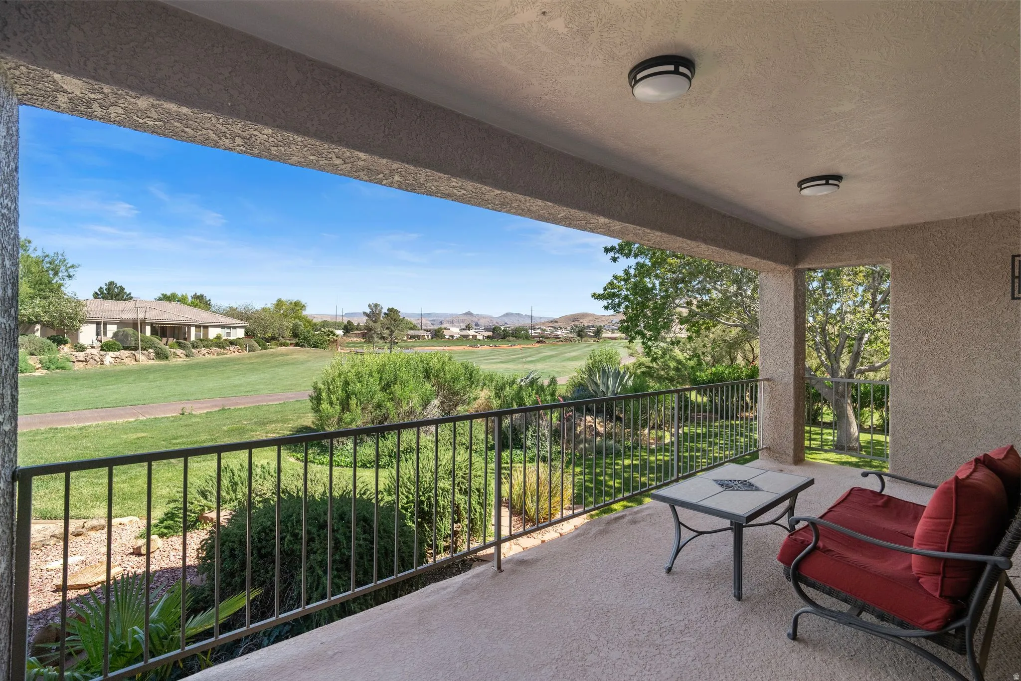 Covered patio featuring a textured concrete floor and a black metal railing
