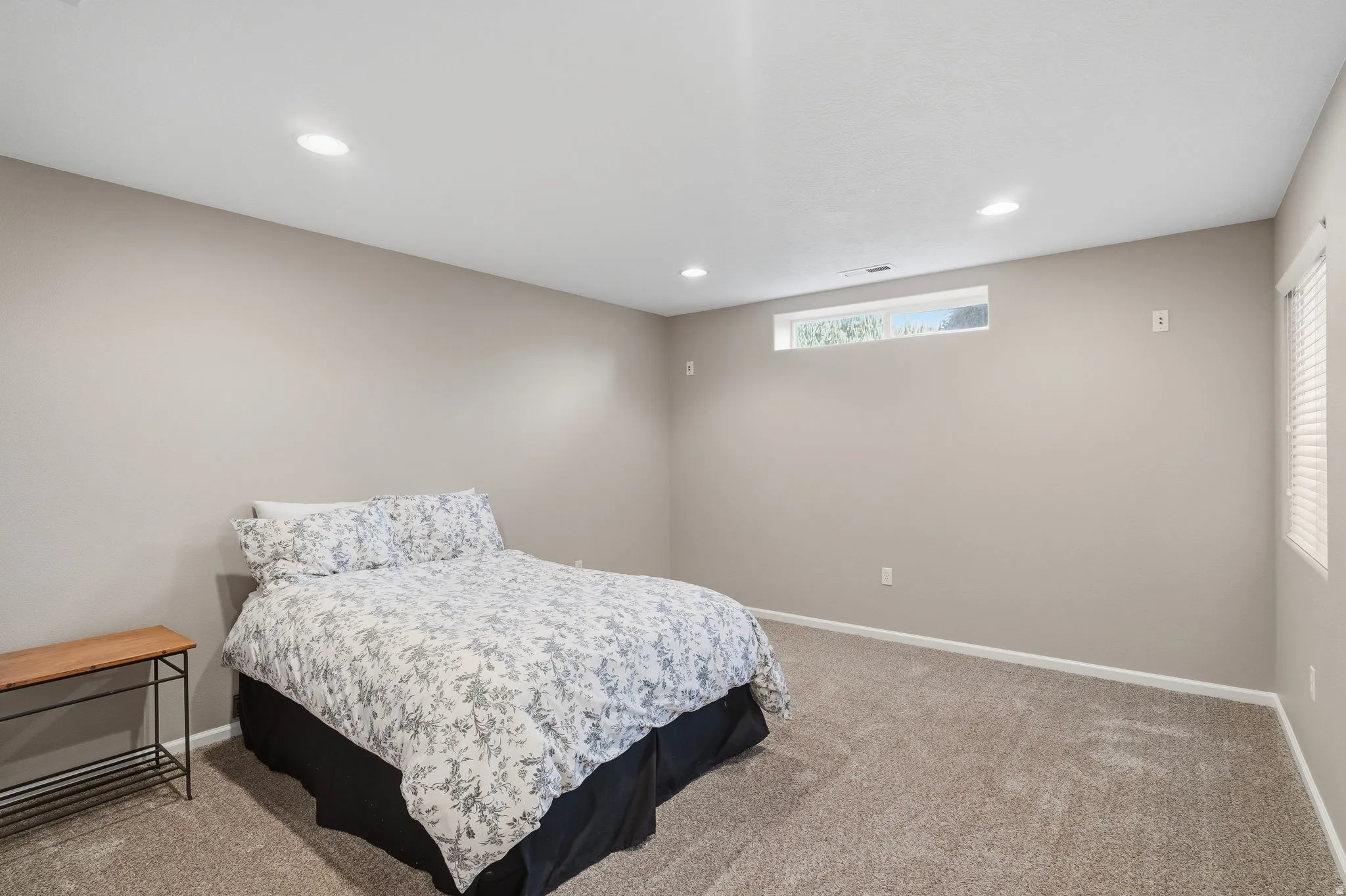 Bedroom featuring neutral-toned walls, recessed lighting, and a horizontal transom window