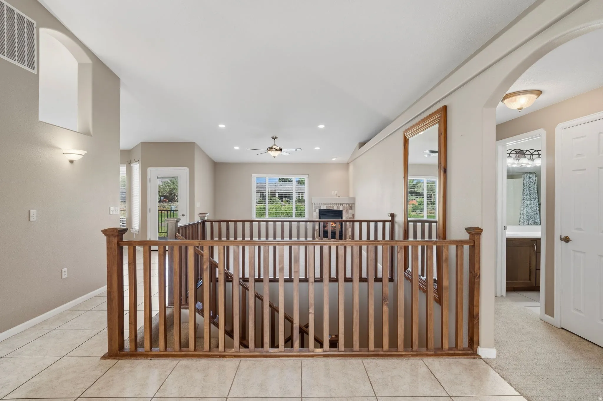 Upper landing with wood railing overlooking the lower level