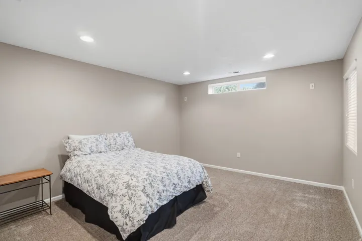 Bedroom featuring neutral-toned walls, recessed lighting, and a horizontal transom window