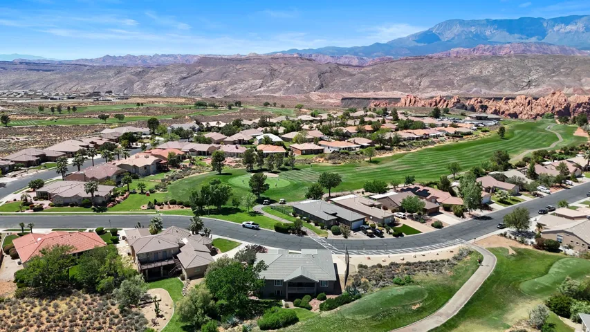 Community featuring a golf course, paved roads, and mature landscaping