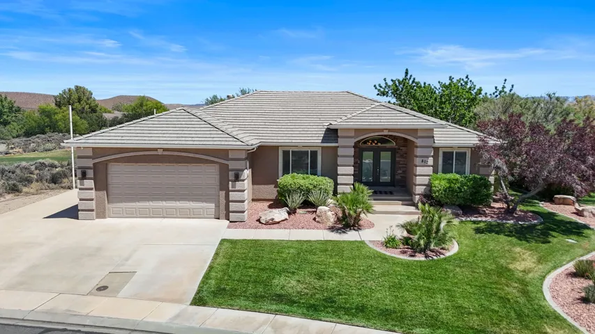 Single-story residence featuring a tile roof, an integrated garage, and a concrete driveway
