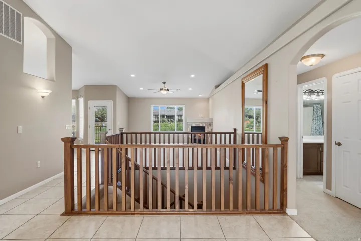 Upper landing with wood railing overlooking the lower level