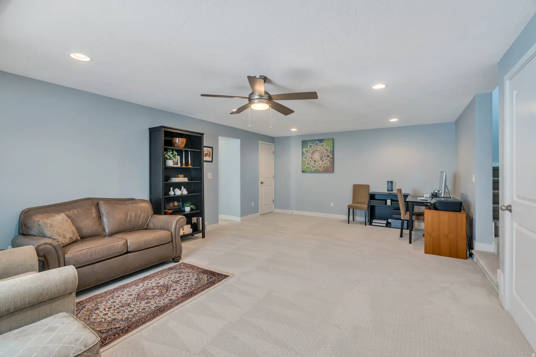 Spacious room featuring light-toned carpeting and light blue wall finishes