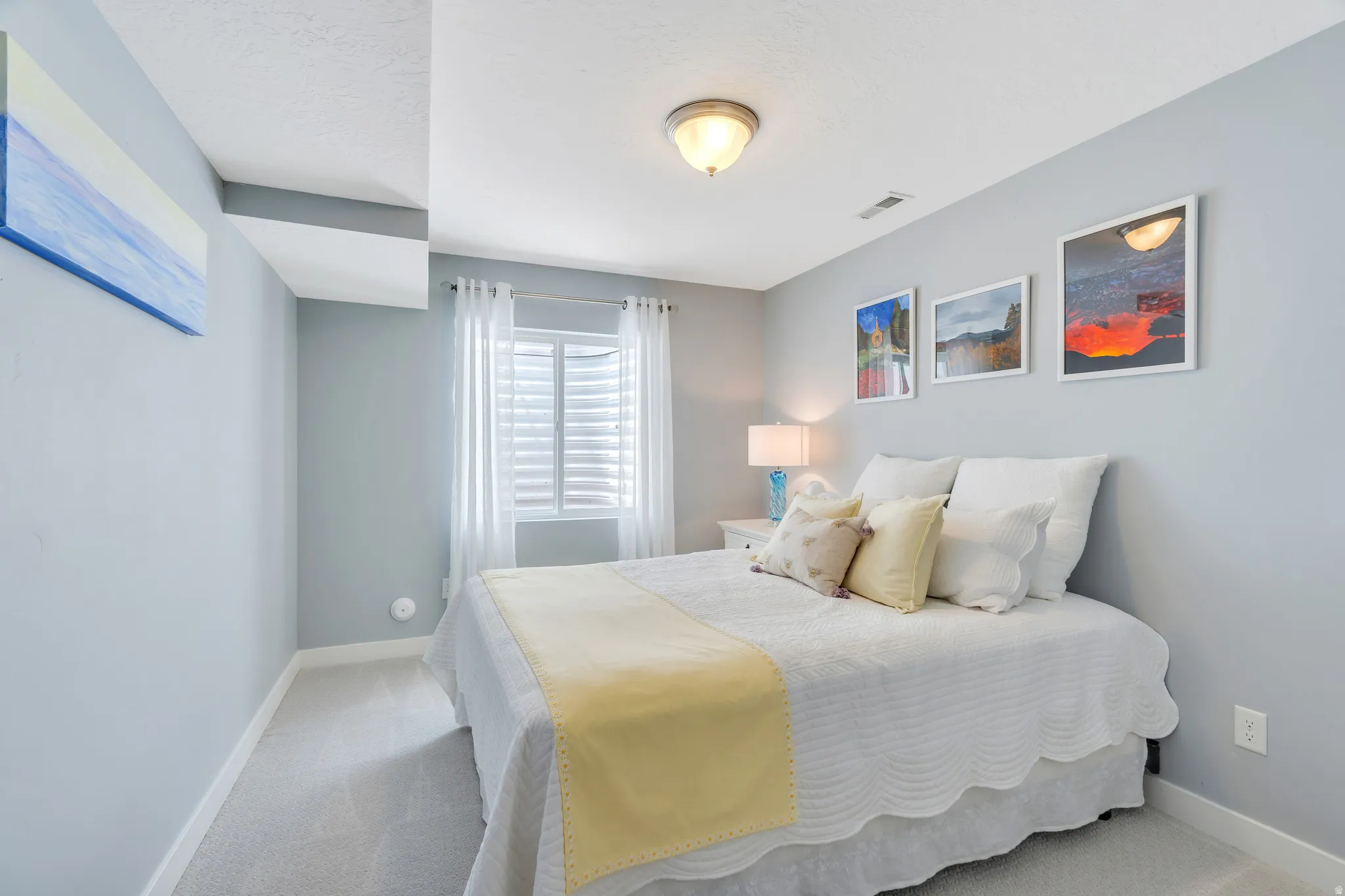Light-filled room featuring carpet flooring, crisp white trim, and a window with plantation shutters and sheer curtains