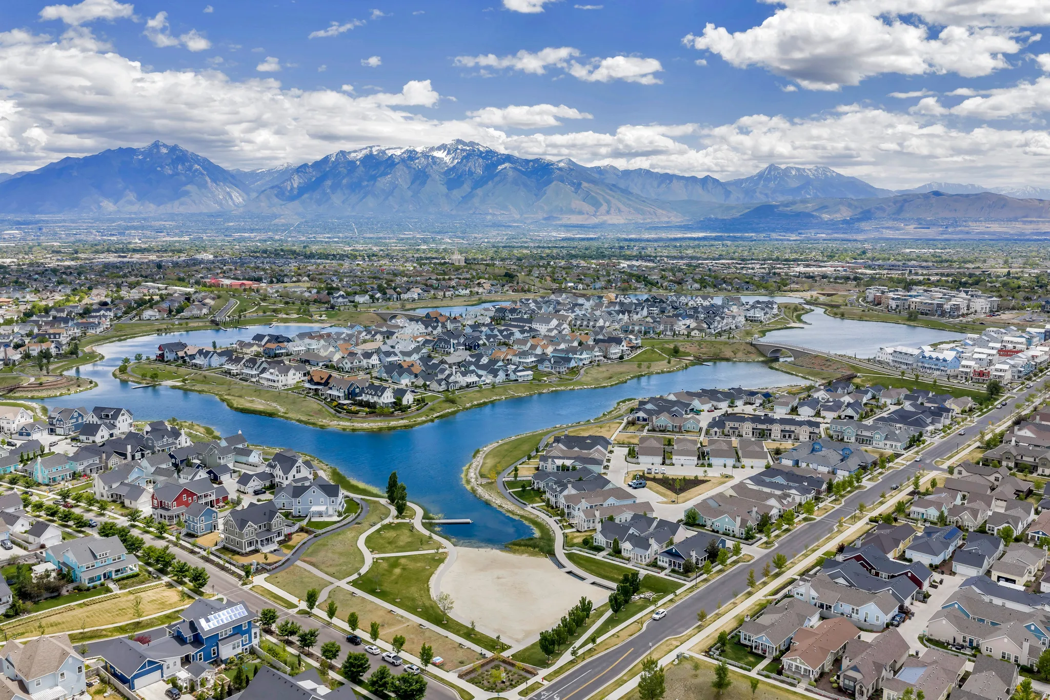 Expansive aerial perspective showcasing a residential community with a prominent central lake feature