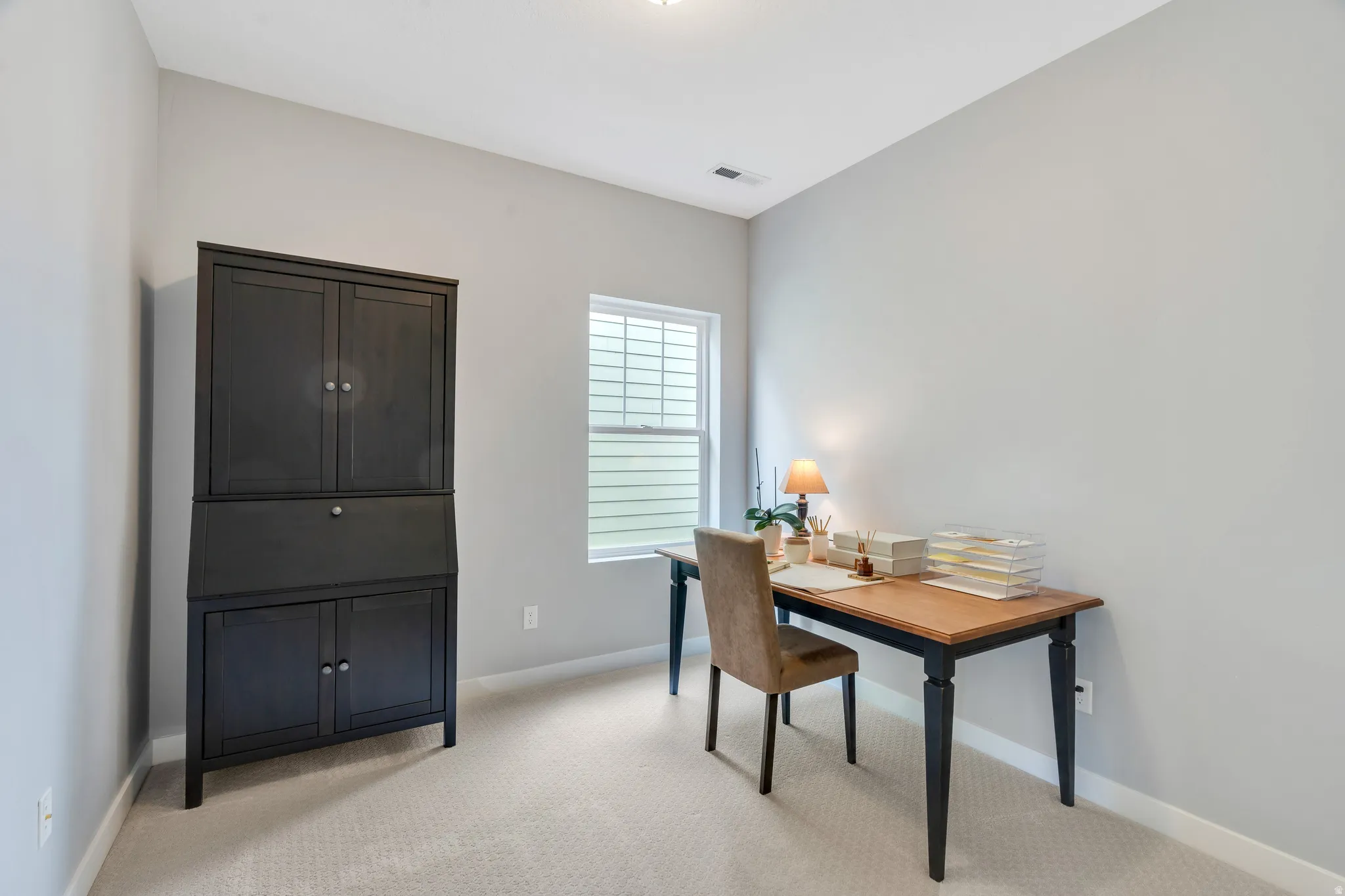 Light-filled room featuring neutral wall paint and carpeting