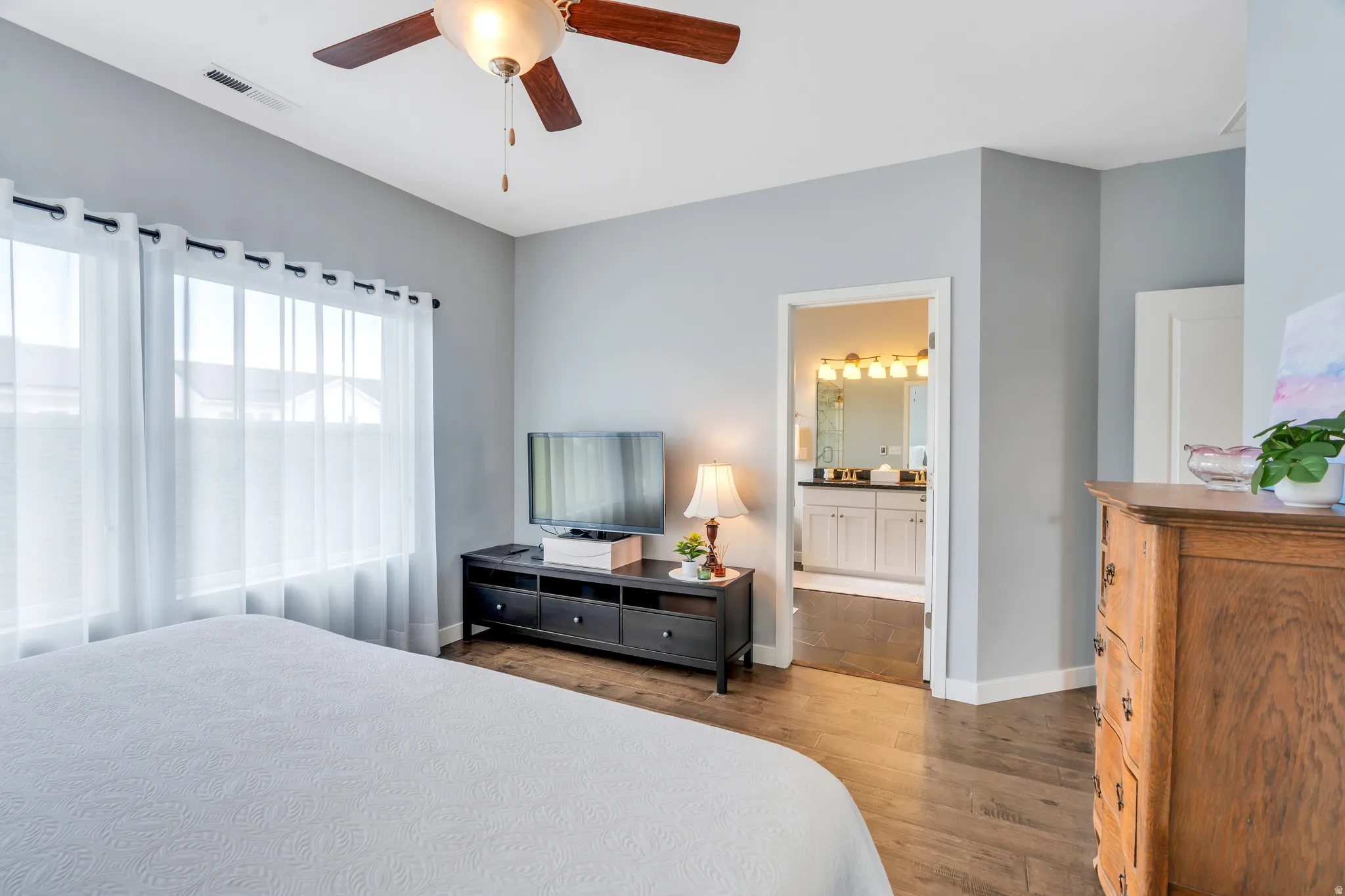 Hardwood-finish flooring throughout, featuring a ceiling fan with integrated lighting