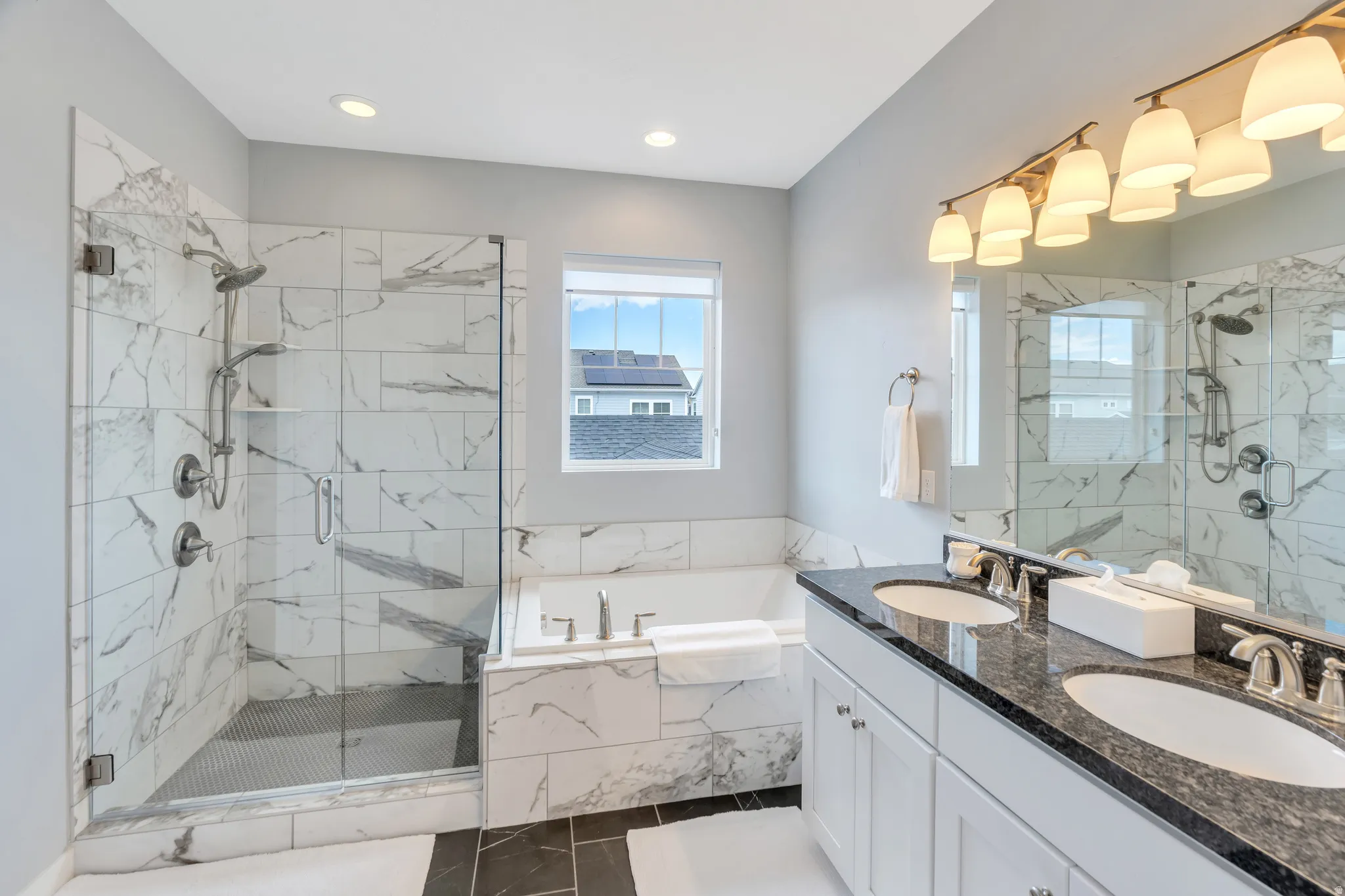 Bathroom featuring a glass-enclosed shower with a built-in bench, a separate bathtub, a double vanity with an integrated countertop, and recessed lighting