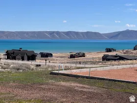 Expansive waterfront property featuring a large body of water, distant mountains, and a clear sky