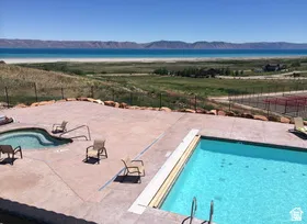 Outdoor swimming pool with a concrete surround, an attached spa, and a natural landscape backdrop