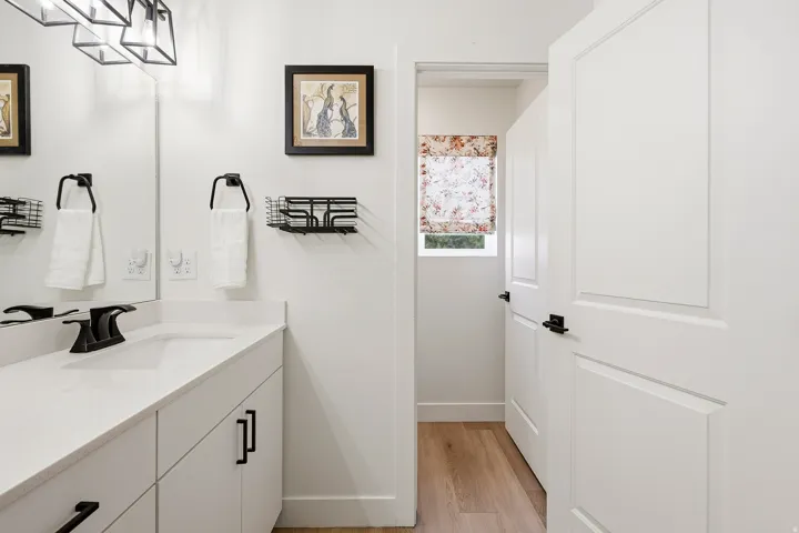 Bathroom vanity with a rectangular undermount sink, quartz countertop, and matte black faucet