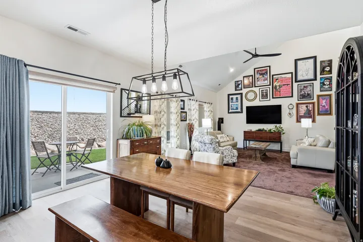 Open-concept living space featuring wood-finish flooring, a vaulted ceiling, and a contemporary chandelier