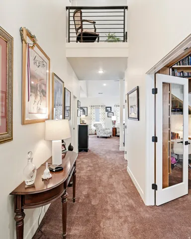 Hallway with plush brown carpeting and white walls