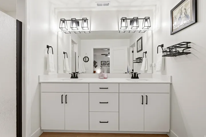 Dual sink vanity with white cabinetry and countertops
