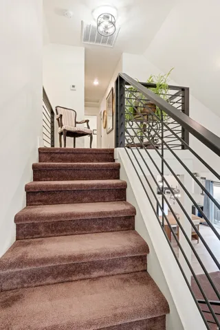 Carpeted staircase with contemporary metal railings