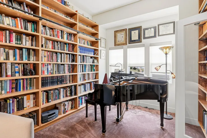Floor-to-ceiling built-in shelving featuring natural wood-finish construction and integrated sliding ladder