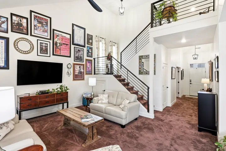 Great room featuring vaulted ceilings, a contemporary metal railing staircase, and a loft overlook