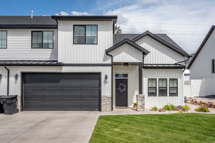 Modern farmhouse-style exterior featuring a black roof and white siding