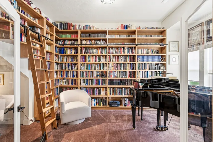 Custom built-in wood shelving with a rolling ladder system