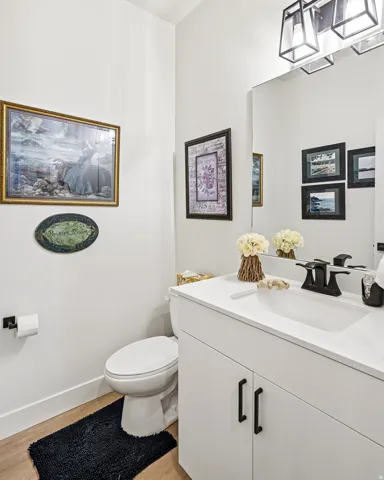 Bathroom featuring a vanity with white cabinetry, a rectangular undermount sink, and a black faucet