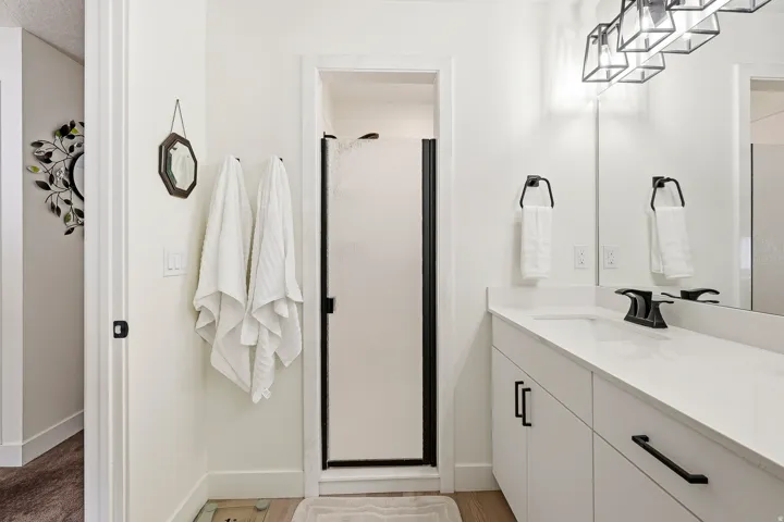 Bathroom featuring a white vanity with a single basin, integrated countertop, and matte black faucet