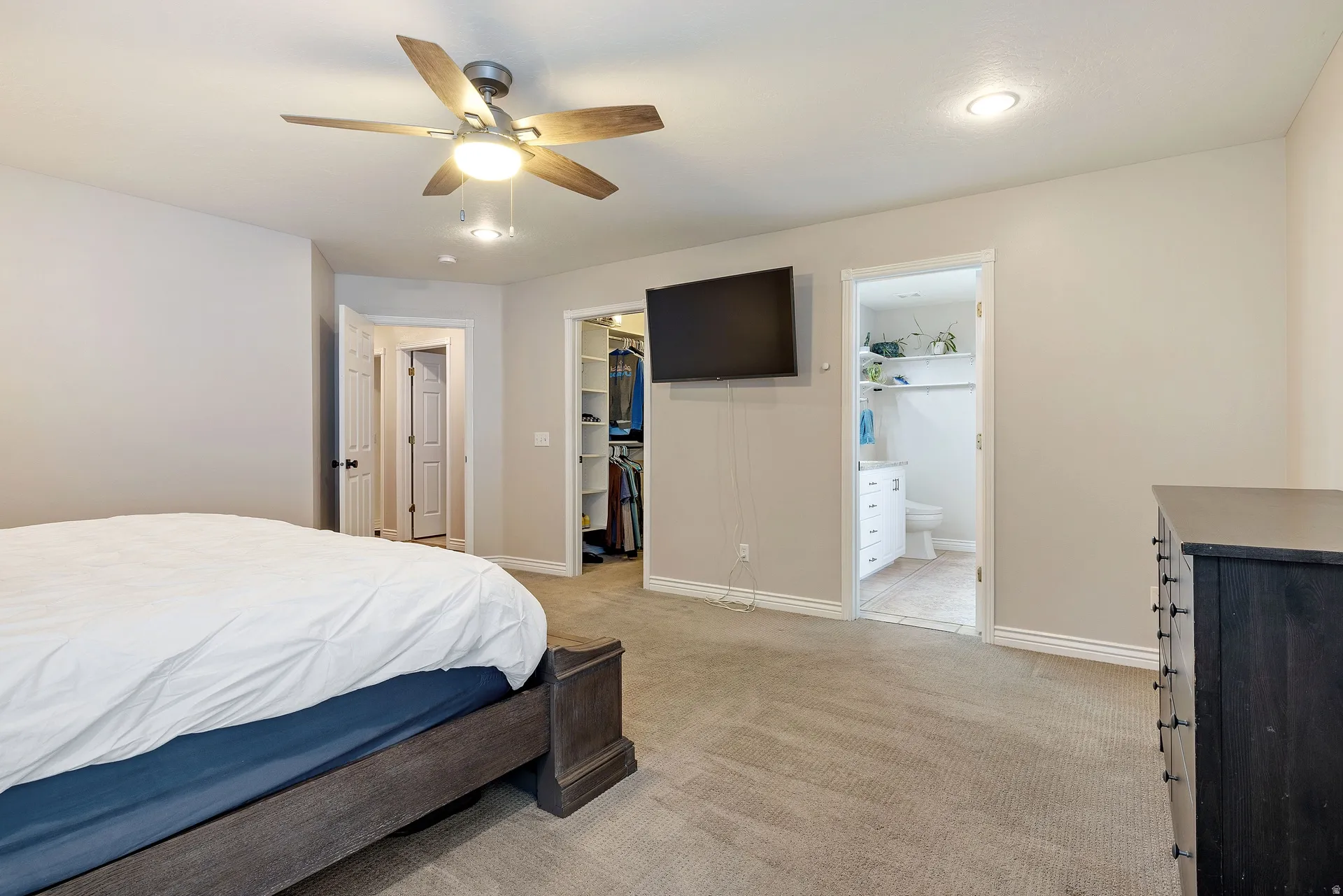 Carpeted room featuring a ceiling fan with integrated lighting, recessed lighting, and white baseboards