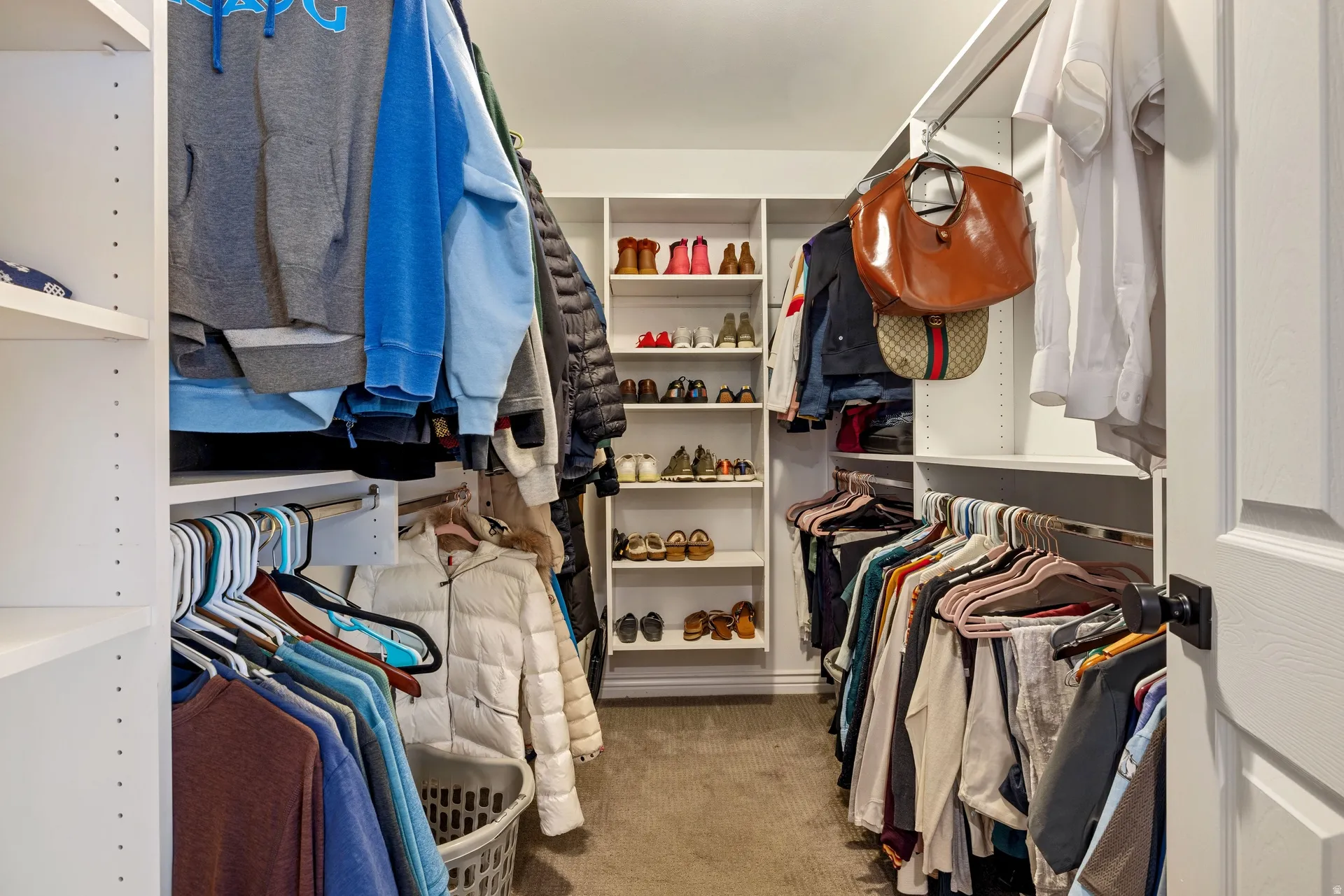 Custom closet system featuring extensive shelving and multiple hanging rods