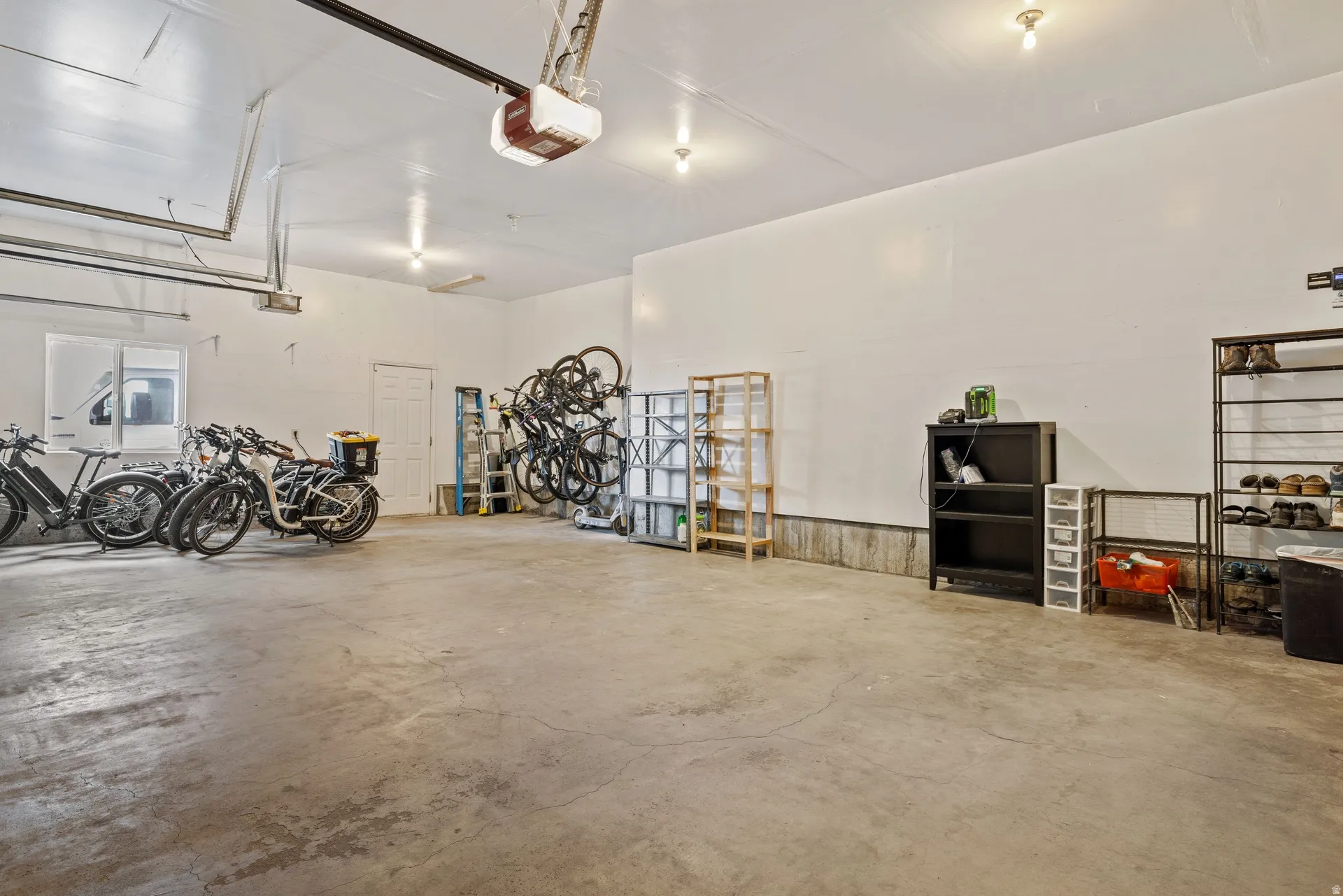 Expansive garage featuring concrete flooring, white painted walls, and overhead lighting