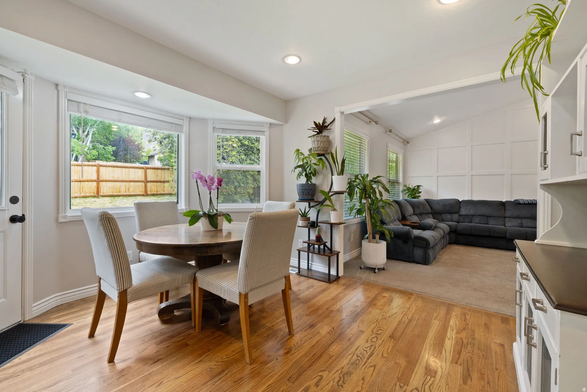 Dining area featuring wood-finish flooring, recessed lighting, and a bay window overlooking a wood fence