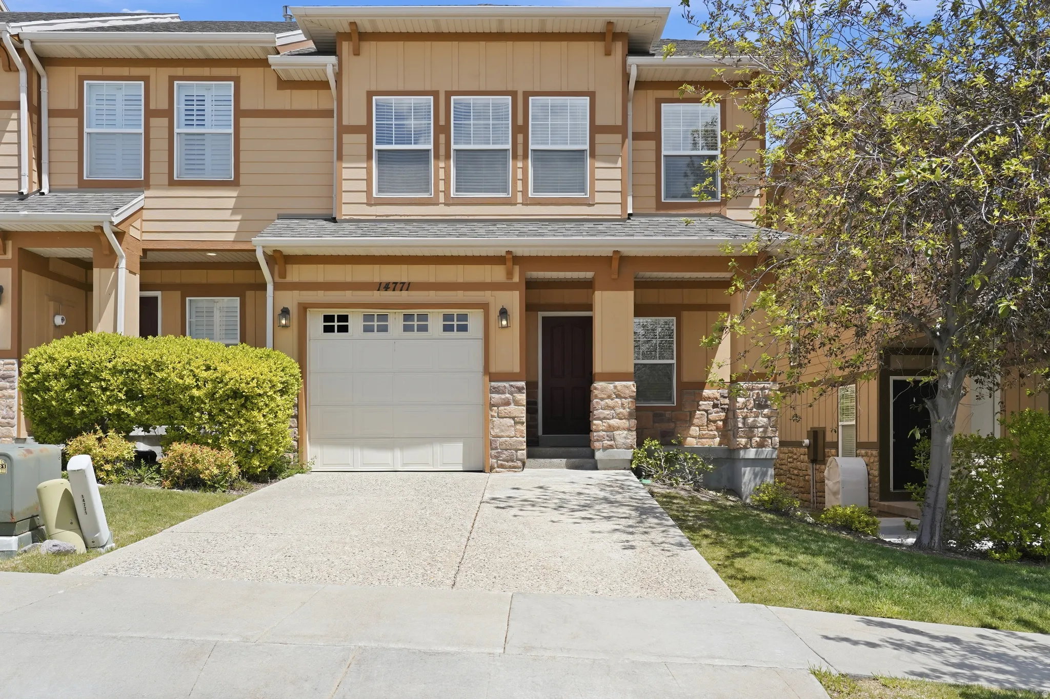 Multi-level exterior featuring tan siding and stone accents