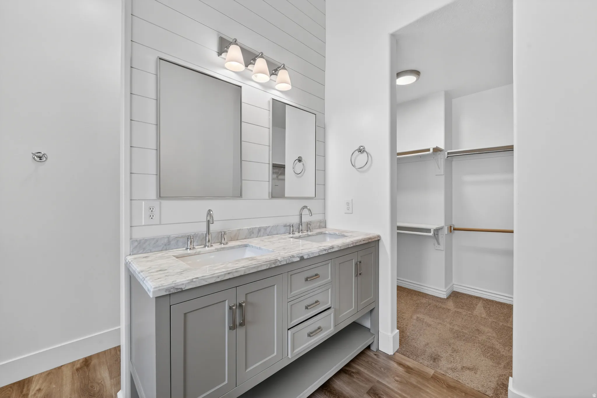 Dual vanity with a stone countertop, individual mirrors, and modern lighting