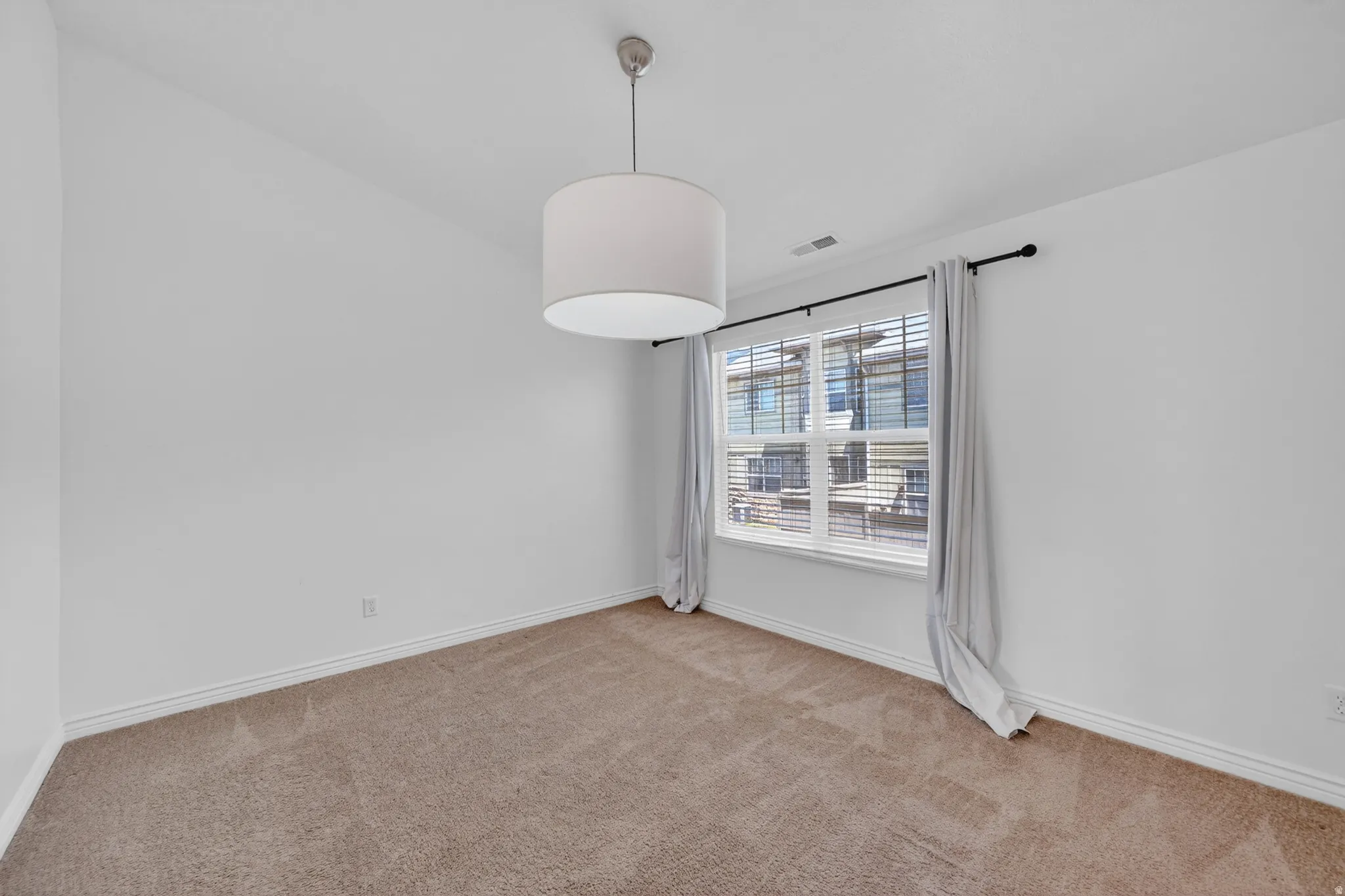 Neutral-toned wall-to-wall carpeting complements the white walls and trim