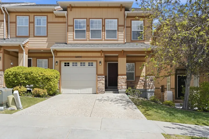 Multi-level exterior featuring tan siding and stone accents