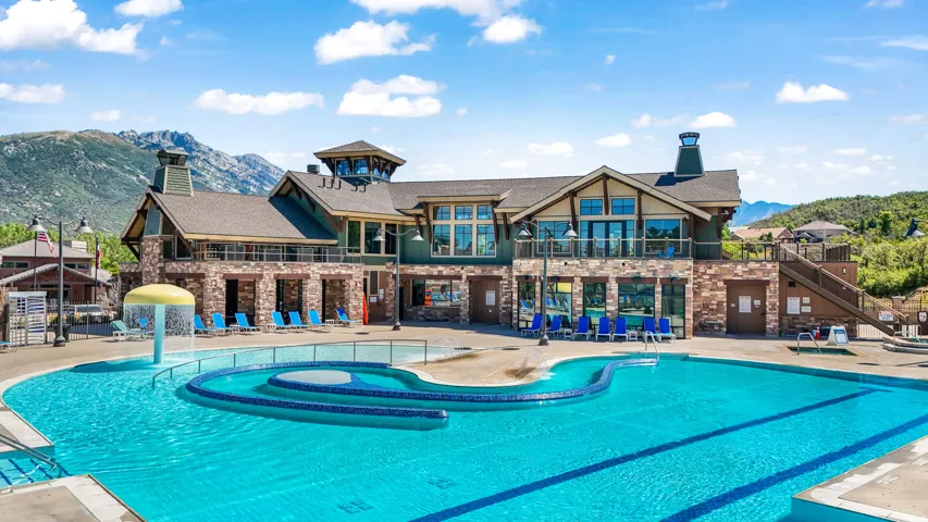 Extensive multi-level swimming pool area featuring a mushroom water feature, a curved seating area, and a surrounding paved deck