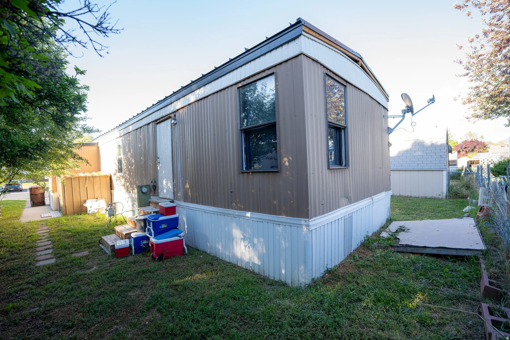 Single-story residence featuring brown siding and white skirting