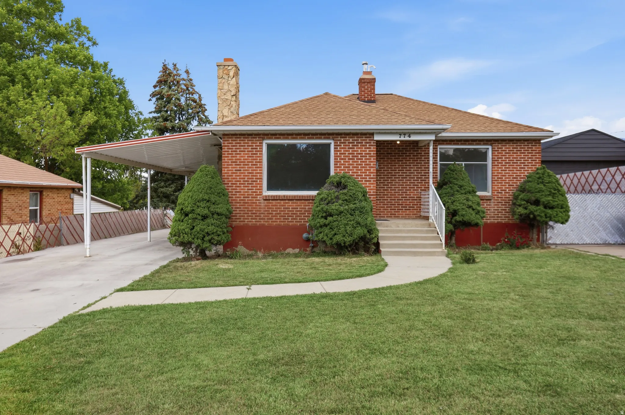 Brick exterior featuring a gabled roof and stone chimney