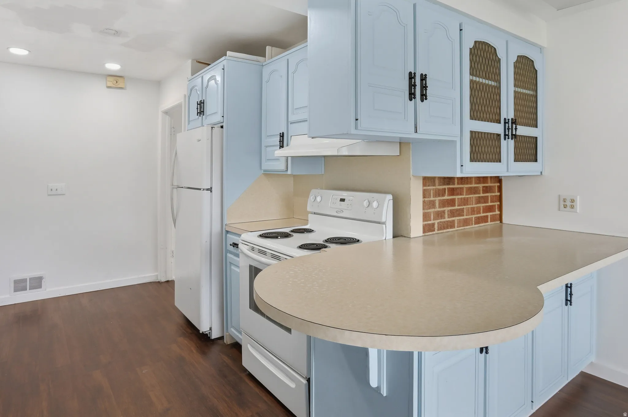 Kitchen featuring light blue cabinetry, a white electric range, a white refrigerator, and wood-finish flooring